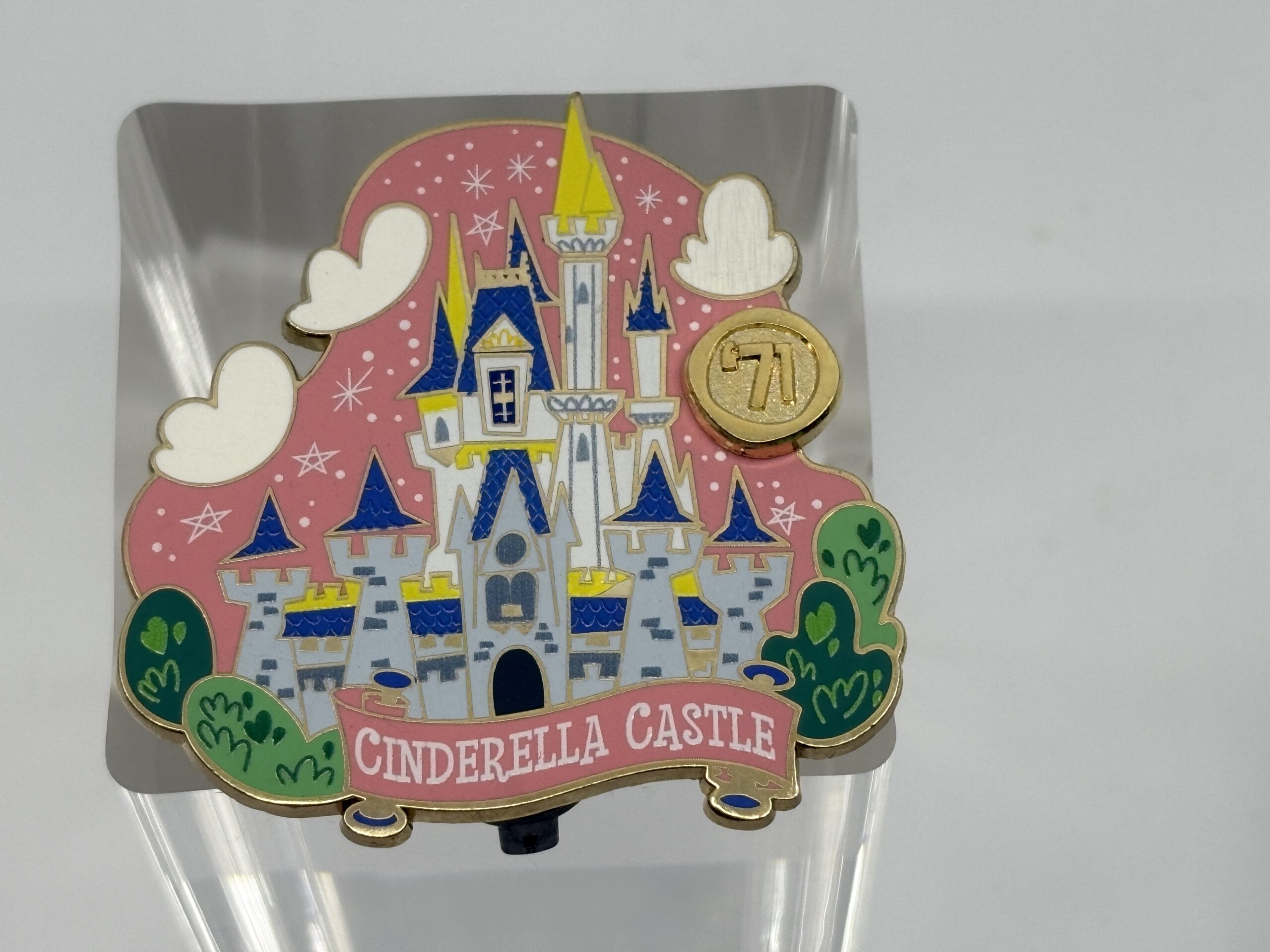 Colorful pin of Cinderella Castle with pink background, white clouds, green bushes—perfect for the WDWNT Summer Auction!