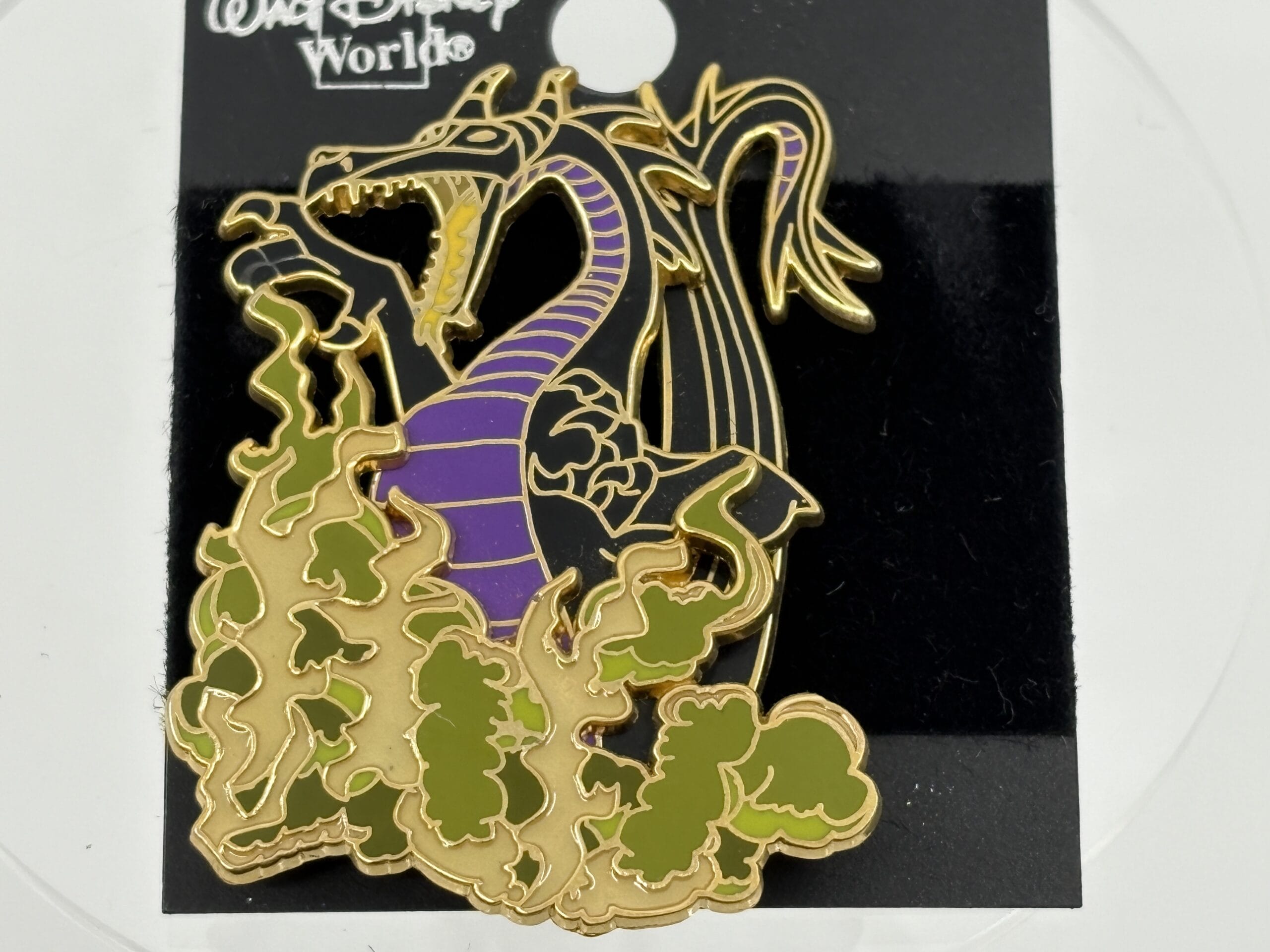 A Disney World pin from the WDWNT Summer Auction features a purple dragon breathing green fire on a black background.