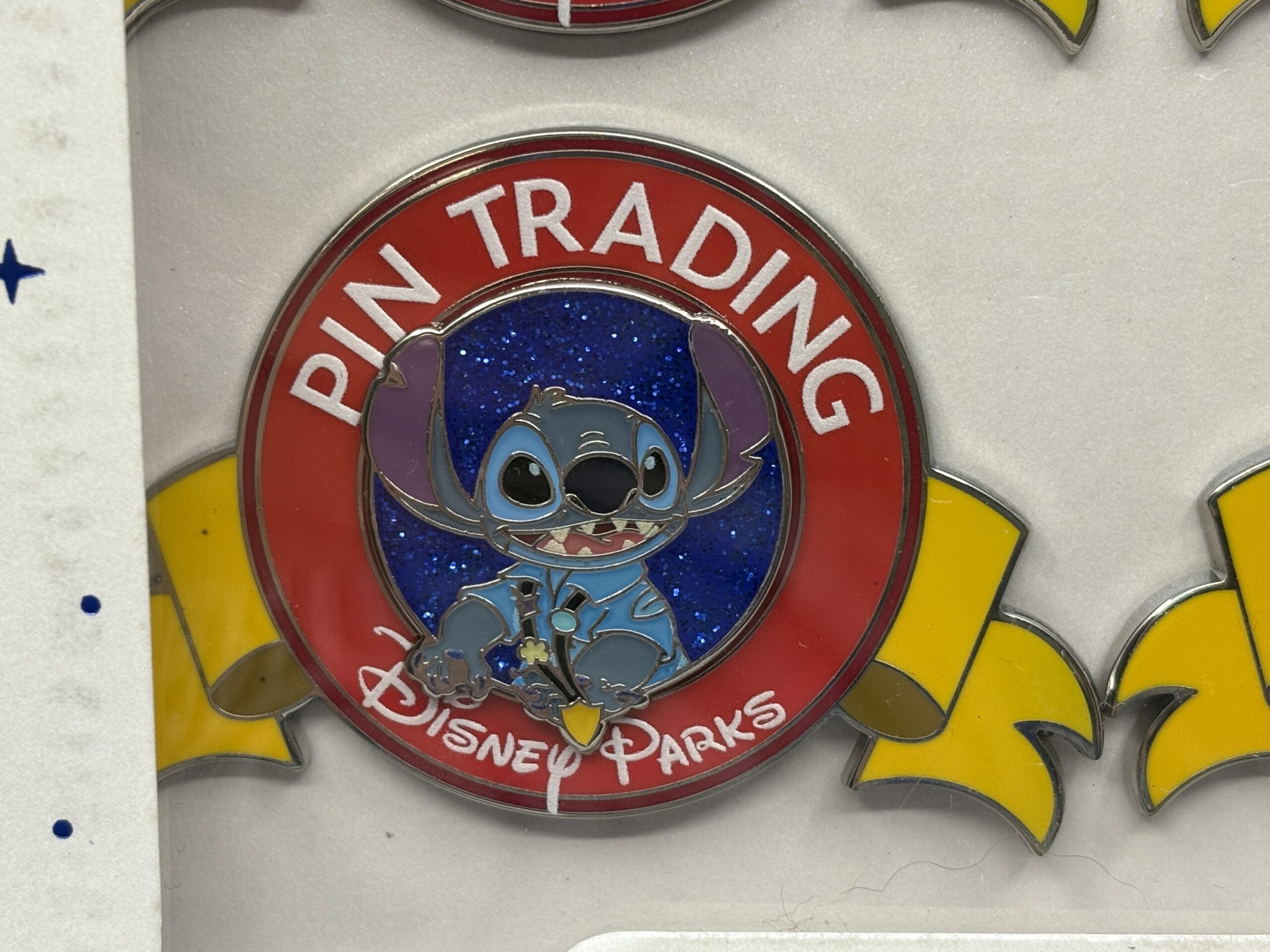 A round Disney Parks pin featuring Stitch, with "Pin Trading" on a red border—perfect for any WDWNT Summer Auction.